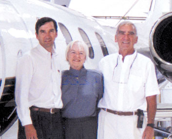 L to R: William J. Mayo III, Gwendolyn O. Mayo and William J. Mayo II standing in front of one of the many jets at Mayo Aviation